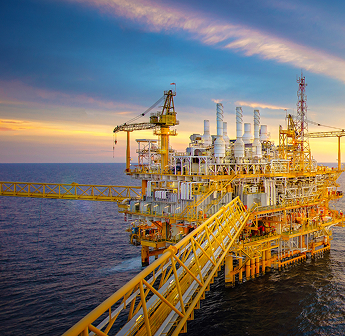 Offshore oil and gas platform at sunset